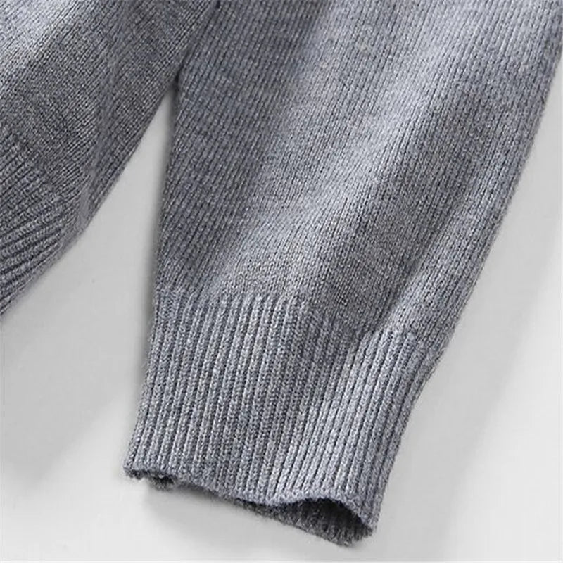 Close-up of the grey knitted sweater cuff and fabric