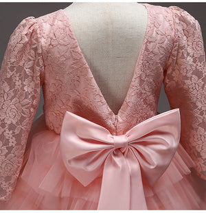 Close-up of the bow and lace sleeves at the back of the pink children's dress