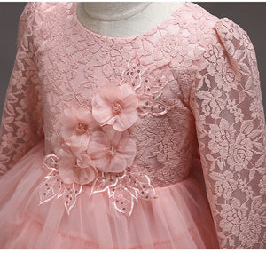 Close-up of floral lace and flower embellishments on the pink children's dress