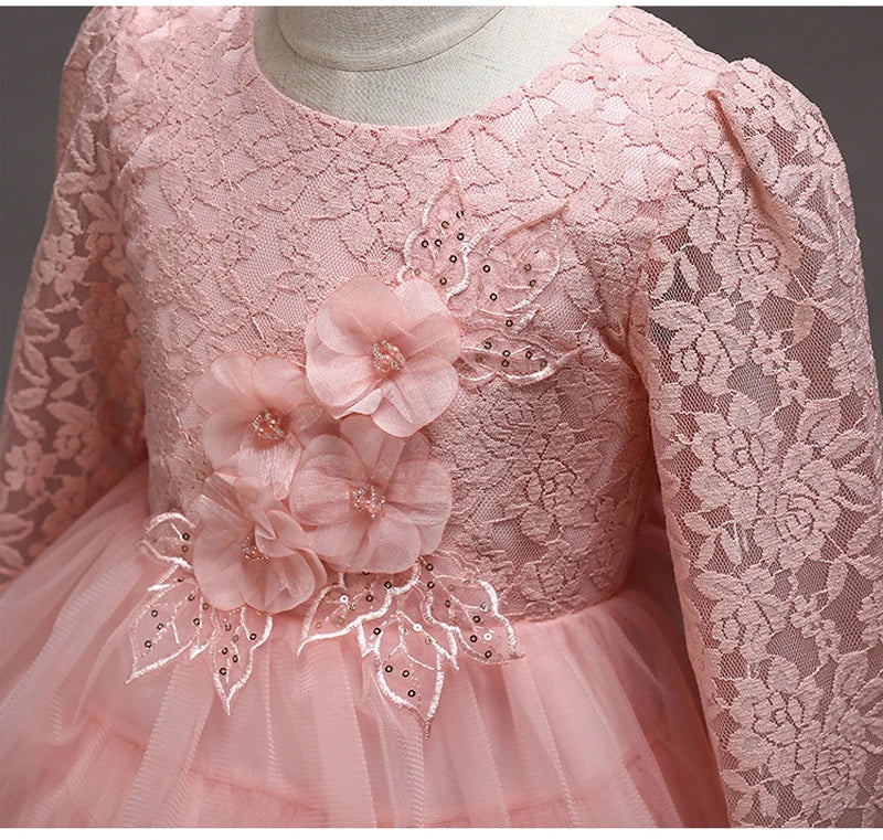 Close-up of floral lace and flower embellishments on the pink children's dress
